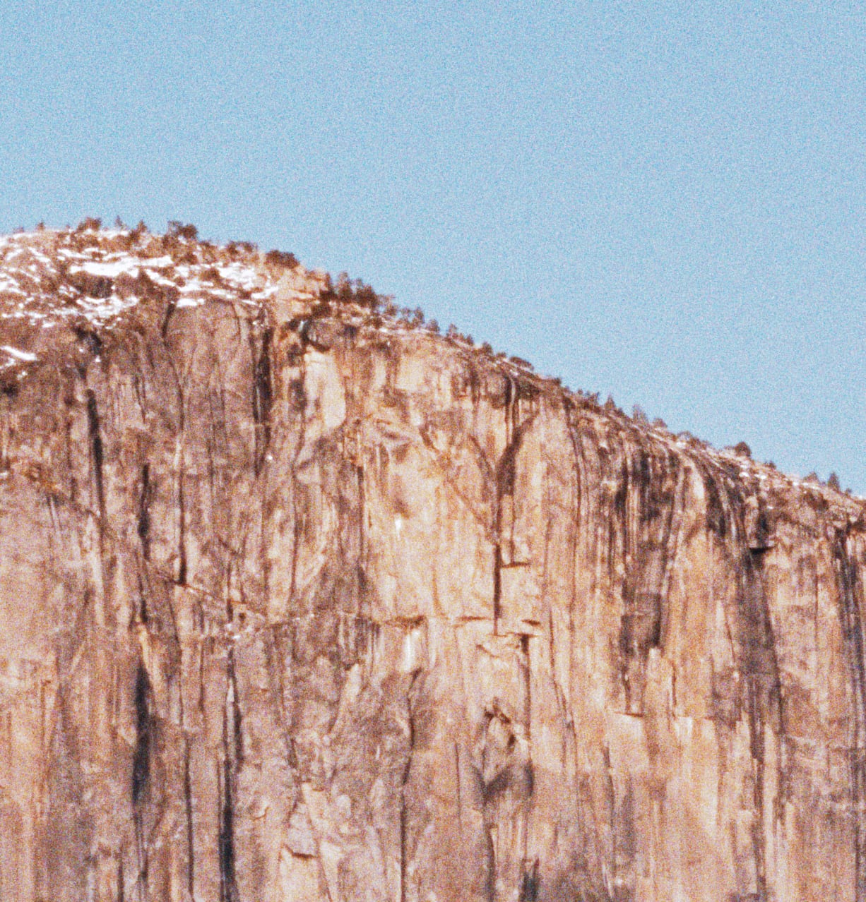 Granite cliff and sky at 1:1, showing film grain rendered per pixel.
